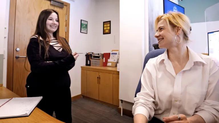 Two female staff members chat at reception
