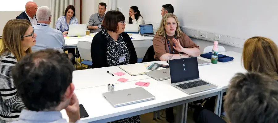 A group of colleagues have a discussion around a desk