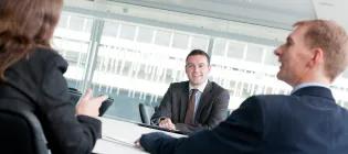 Image shows a group of people having a meeting.