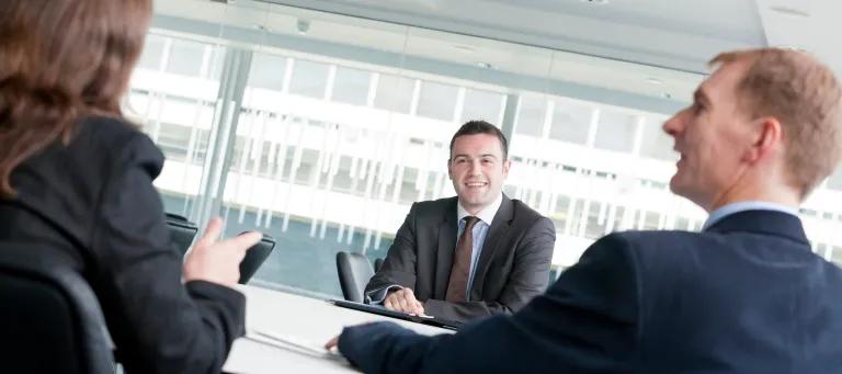Image shows a group of people having a meeting.