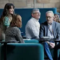 A small group of people sit on sofas in coversation